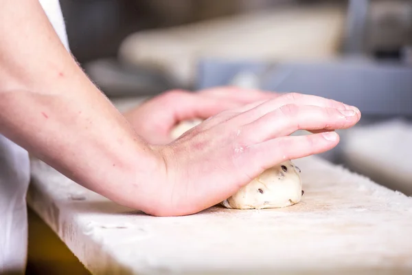 Primer plano de la mano de un panadero amasar y dar forma a la masa — Foto de Stock