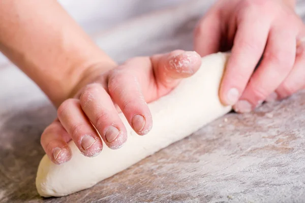 Primer plano de la mano de un panadero amasar y dar forma a la masa — Foto de Stock