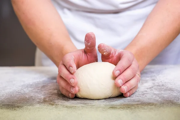 Крупный план руки пекаря месить и формировать тесто — стоковое фото