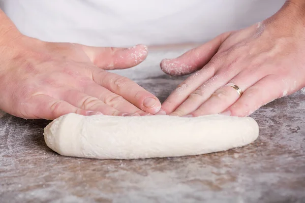 Primer plano de la mano de un panadero amasar y dar forma a la masa — Foto de Stock