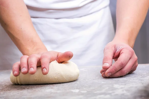 Primer plano de la mano de un panadero amasar y dar forma a la masa — Foto de Stock