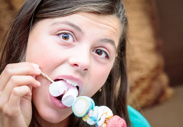 Detailní záběr na pěknou mladou dívku jíst chutné marshmallow špíz — Stock fotografie