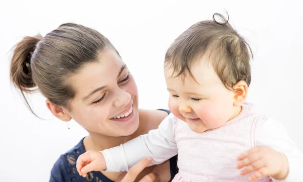 Pretty girl playing with a baby on white background Royalty Free Stock Images