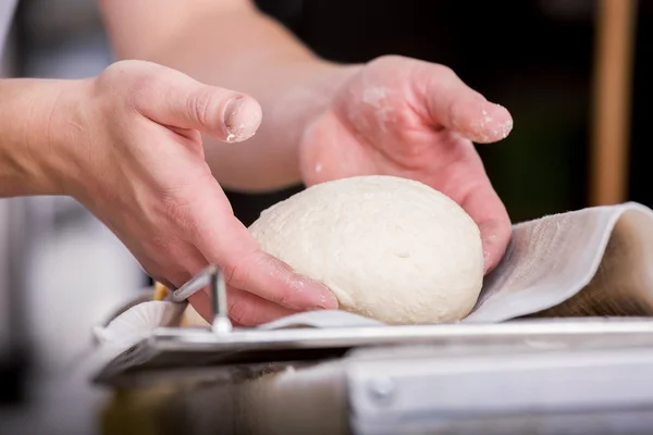 Primer plano de la mano de un panadero amasar y dar forma a la masa — Foto de Stock