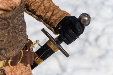 Orta çağ kılıcının kabzasını tutan el.