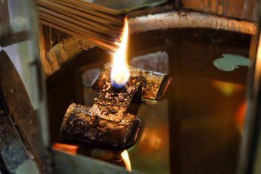 İnsanlar, tanrılara dua etmek için bir tapınaktaki bir yağ lambasında tütsü çubuğu yaktılar. Asya inançları dini töreni.