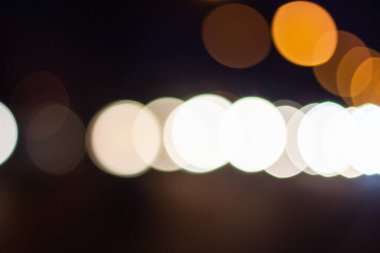 Odak dışında güzel, parıltılı, bulanık arabalar ve gece trafik ışıkları. Şehir caddesinde bulanık trafik sıkışıklığı. Şehir caddesinde trafik sıkışıklığının sönük renkli ışıkları