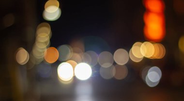 Odak dışında güzel, parıltılı, bulanık arabalar ve gece trafik ışıkları. Şehir caddesinde bulanık trafik sıkışıklığı. Şehir caddesinde trafik sıkışıklığının sönük renkli ışıkları