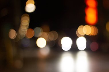 Odak dışında güzel, parıltılı, bulanık arabalar ve gece trafik ışıkları. Şehir caddesinde bulanık trafik sıkışıklığı. Şehir caddesinde trafik sıkışıklığının sönük renkli ışıkları