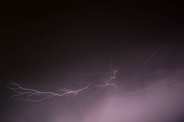 Yağmurdan önce karanlık gökyüzünde yıldırımlar çakıyor.