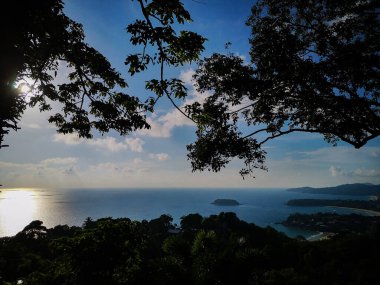 Güzel denizin siluet ağacı ve 3 körfez manzaralı güneş ışığıyla muhteşem bulutlu gökyüzü.