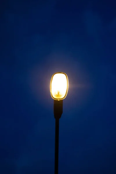 街上的灯柱在深蓝色的天空背景上发出橙色的光 让你感到寂寞 科皮空间 — 图库照片