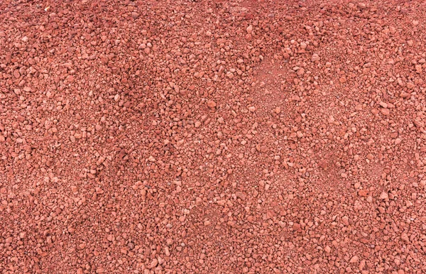 Küçük kırmızı lav taşları doku plaj — Stok fotoğraf