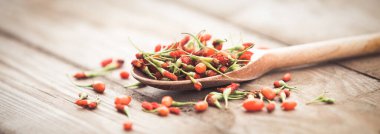 Ahşap arka planda olgun goji üzümleri