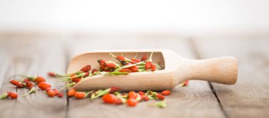 Ahşap arka planda olgun goji üzümleri