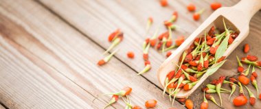 Ahşap arka planda olgun goji üzümleri