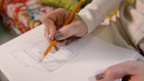 Chica dibuja un lápiz en bocetos de dibujo de papel. Primer plano — Vídeos de Stock