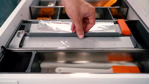 Functionele snijplotter voor voedselfilm ook een snijplotter voor aluminiumfolie. Open la met verschillende gebruiksvoorwerpen in de keuken. — Stockvideo