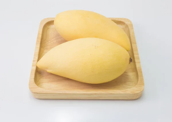 Fresco delizioso mango giallo in lastra di legno isolato su b bianco — Foto Stock