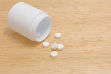 Hap hap şişesi üzerinde ahşap arka plan dışarı dökülmesini