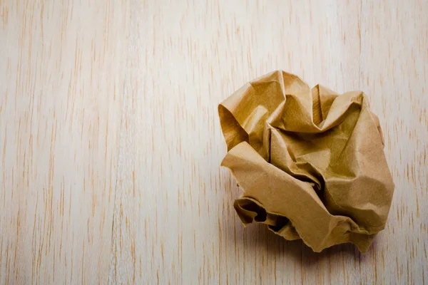 Bruine papieren bal geïsoleerd op hout achtergrond — Stockfoto