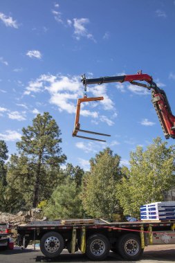 Large boom crane equipment being used for a roofing project for a residential house clipart