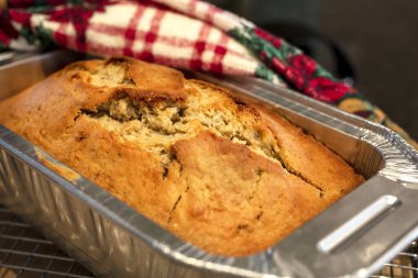 Alüminyum bir tavada pişmiş altın kabuklu muz ekmeği ve Noel sezonu için bayram havlusu.