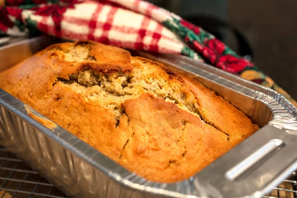 Alüminyum bir tavada pişmiş altın kabuklu muz ekmeği ve Noel sezonu için bayram havlusu.