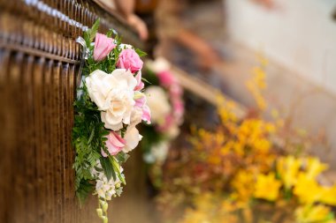 Pembe ve beyaz gül buketi kilisenin korkuluklarından sarkıyor düğün töreni için.