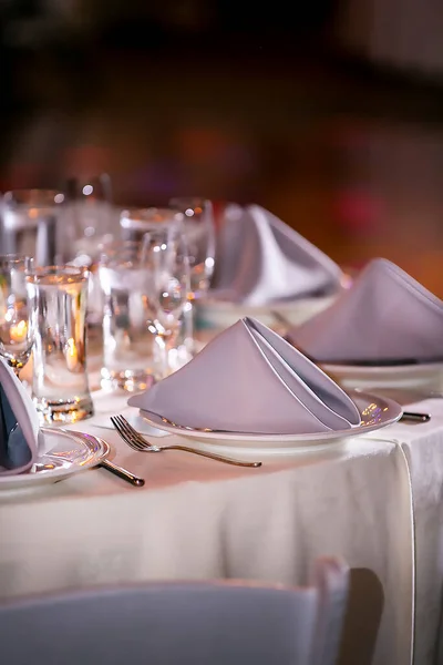 キャンドルや花を中心とした夜のディナーの結婚式のためのエレガントなテーブルを設定します — ストック写真