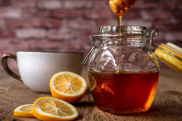 Glas Honig Das Von Einer Honigstange Mit Einer Zitronenseite Auf — Stockfoto