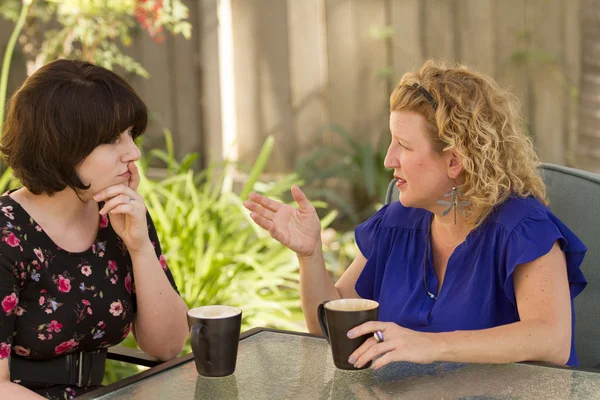 2 人の女性の共有とコーヒーを飲みながらおしゃべり. — ストック写真