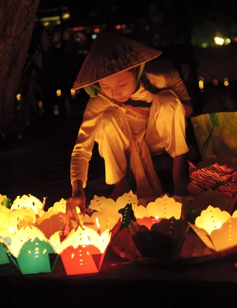 Two small kids selling handmade lanterns to tourists in the streets at July 23, 2013 in Hoi An, Quang Nam, Vietnam. — Stockfoto
