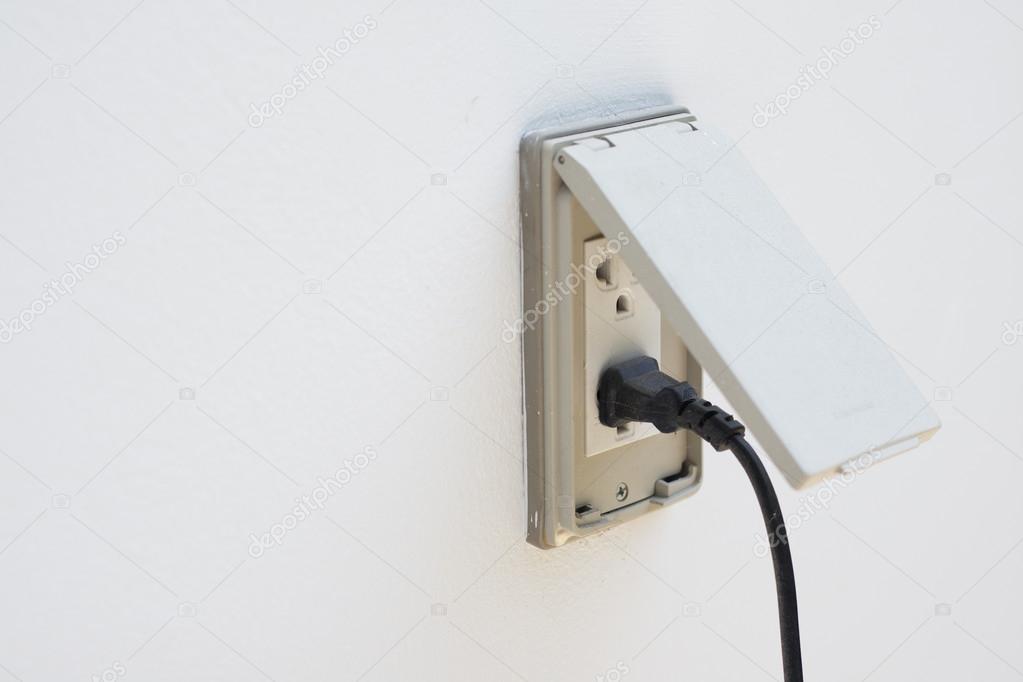Black plug plugged in a socket with cover for outdoor