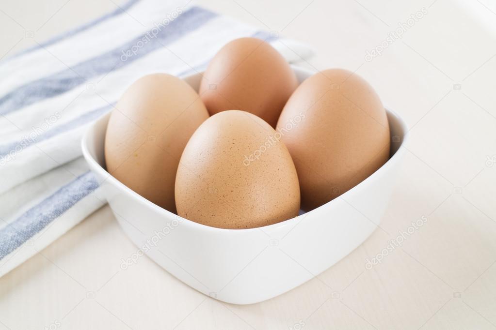 Яйцо в белой миске, деревянная тарелка 