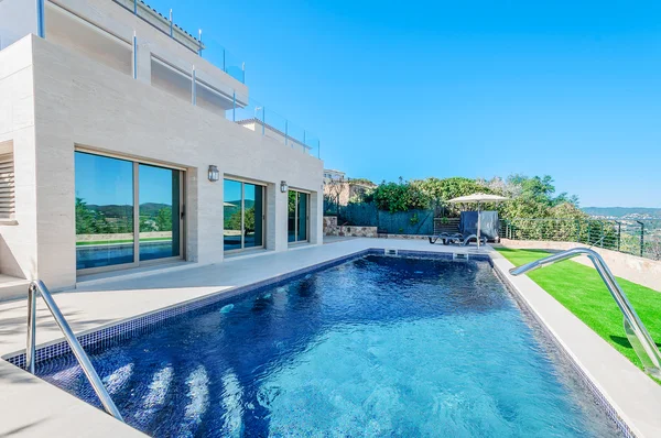 Casa moderna de luxo com piscina com jato de cascata. Casa — Fotografia de Stock