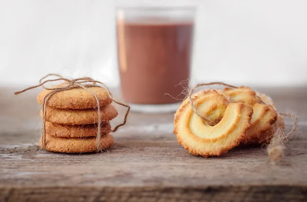 Galletas de mantequilla primer plano sobre fondo de madera rústica con una taza — Foto de Stock