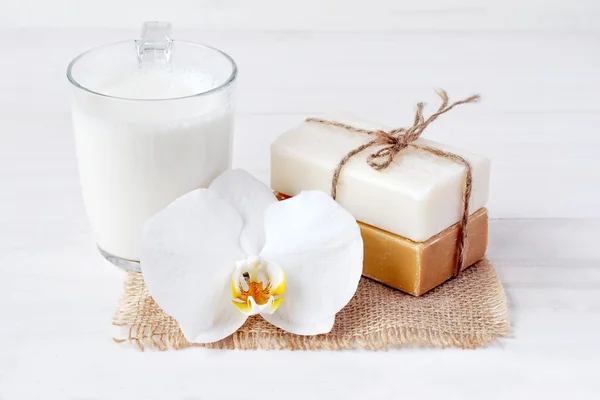 Set de jabón natural, esponja de baño, vaso de leche y flor de orquídea , — Foto de Stock