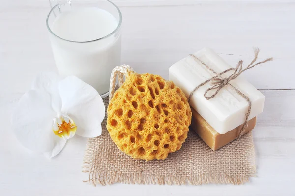 Set de jabón natural, esponja de baño, vaso de leche y flor de orquídea , — Foto de Stock