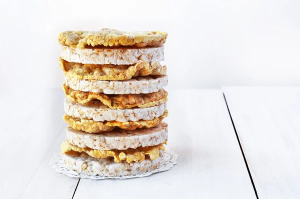 Round rice cakes and corn cakes on wooden table.