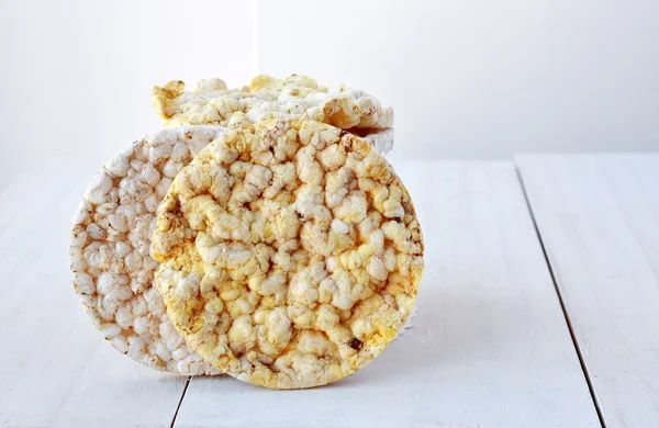 Round rice cakes and corn cakes on wooden table.