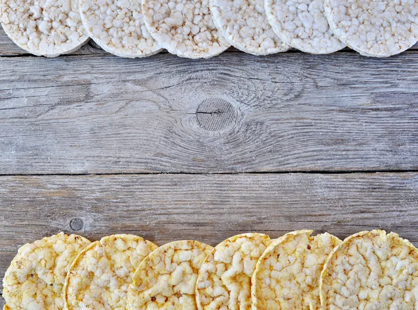 Round rice cakes and corn cakes on wooden table. With space for