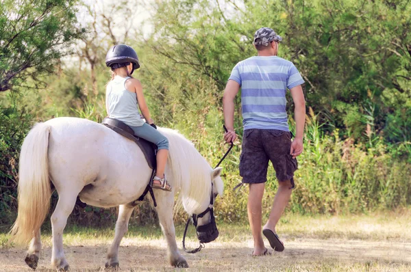 Тато вчить свою дочку, щоб їздити на коні. Урок з їзда Ins — стокове фото