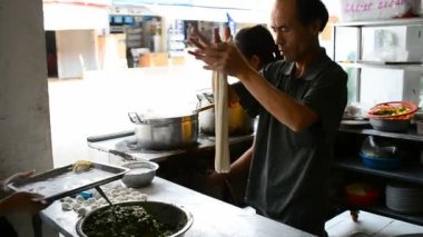 BATTAMBANG, CAMBODIA - 9 Mart 2017: aşçıların el yapımı erişte pişirdiği sokak sahnesi Battambang, Kamboçya, Asya