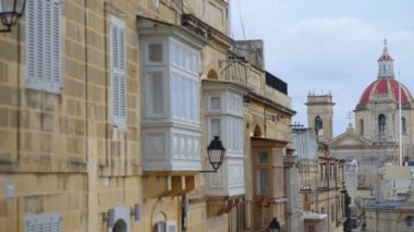 Victoria kasabasının balkonunda arka planda Aziz George Bazilikası kulesi olan cadde, Gozo Adası, Malta, Avrupa.