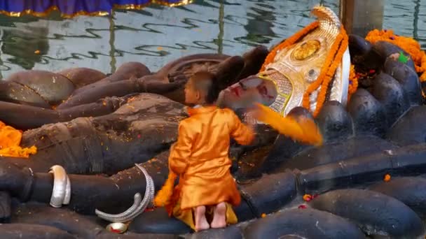 2017年12月25日ネパール カタンドゥー 若い僧侶がネパール ブダニルカンタ寺院 アジアの仏教寺院で仏像をリクライニングの掃除をしている — ストック動画