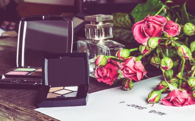 Aksesuarlar için bir makyaj ve masanın üzerine gül