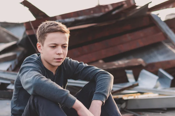 Сидящий на крыше дома озлобленный подросток — стоковое фото