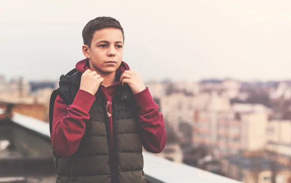 Adolescent sérieux assis sur le toit de la maison — Photo