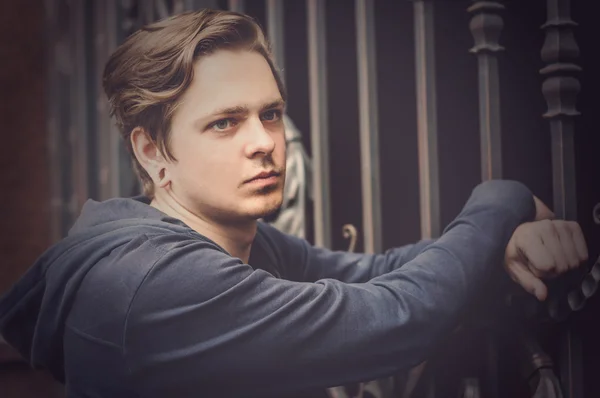 Young handsome man near the lattice — Stock Photo, Image